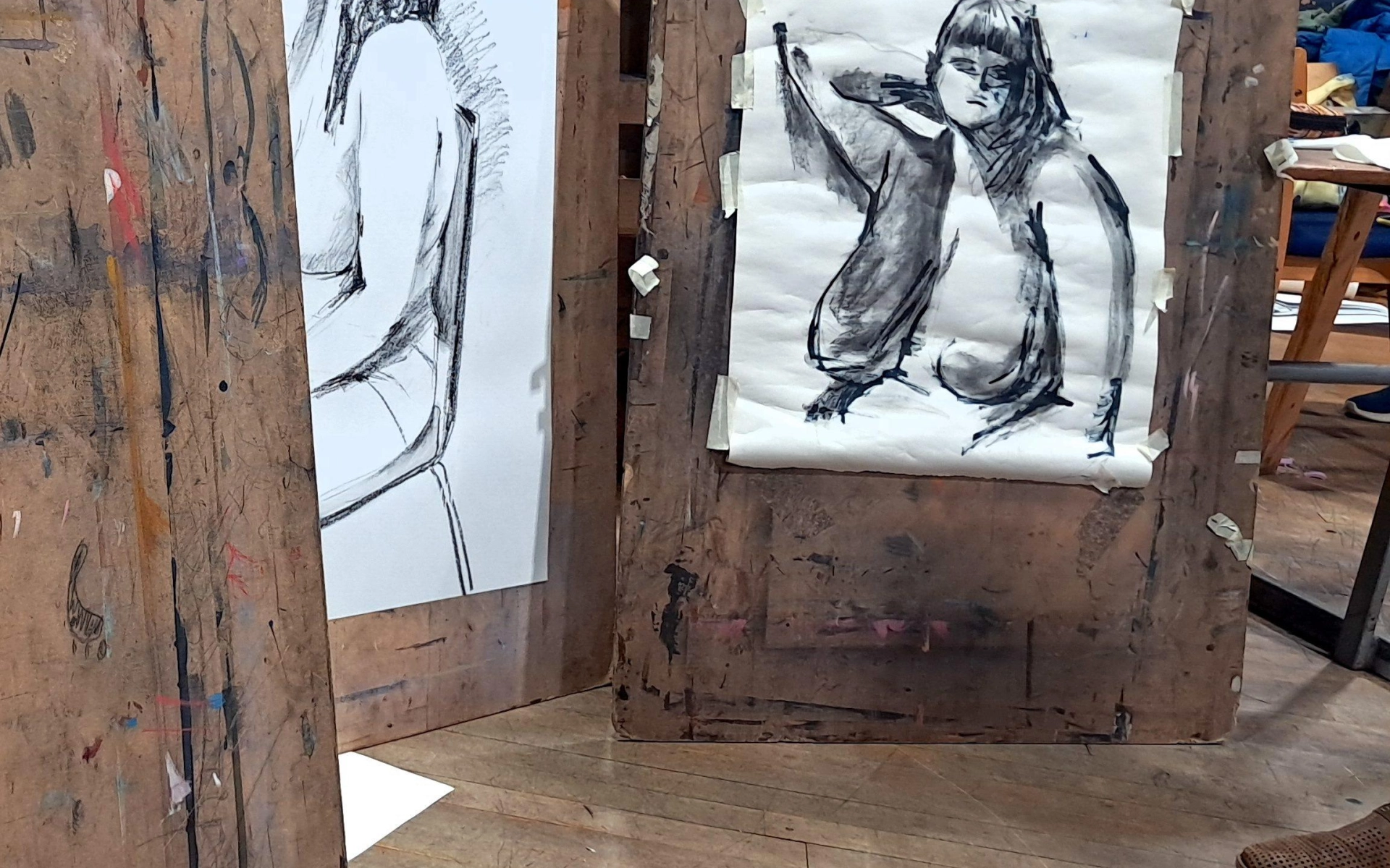 Three easel's upright showing a sketched image of a nude woman.