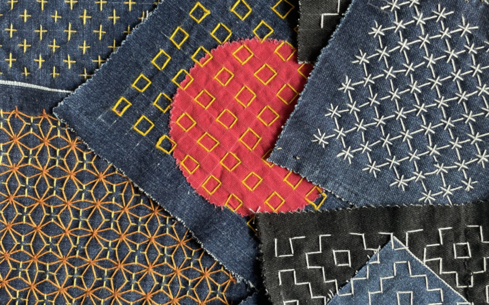 An image showing examples of square teal and dark green pieces of cloth, decorated with Sashiko Stitch pattern technique.